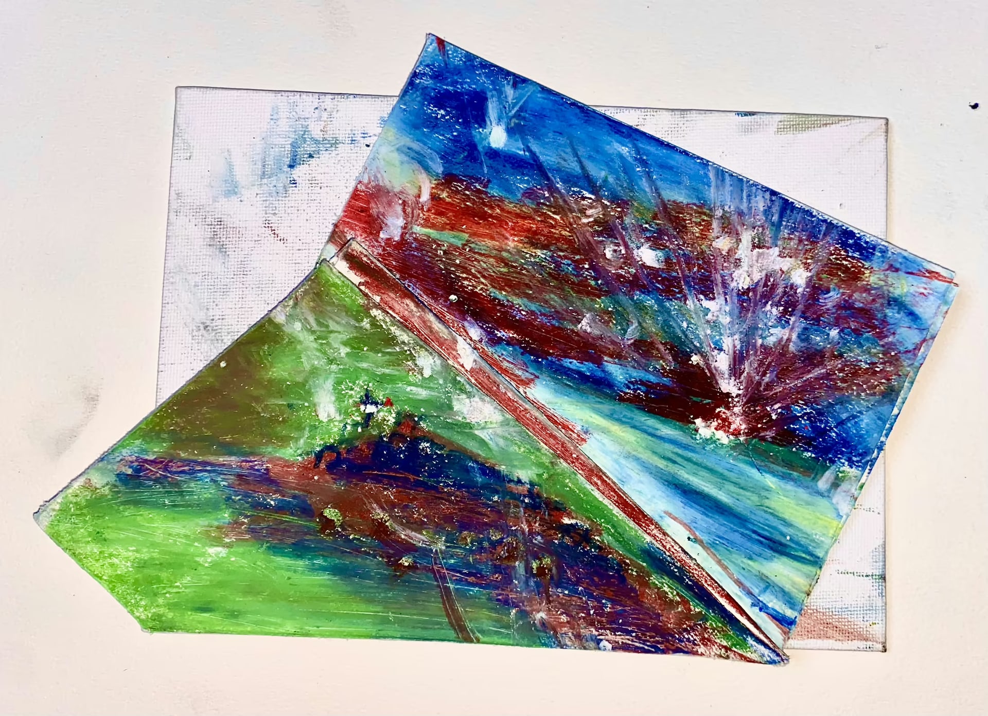 Three overlapping abstract works on paper combine green, blue, red and violet paint with diagonal marks.